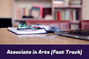 Associate in Arts (Fast Track): photo of a textbook, glasses and a laptop on a table