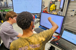 SEED Program: Two students looking at bridge design plans on a computer screen.